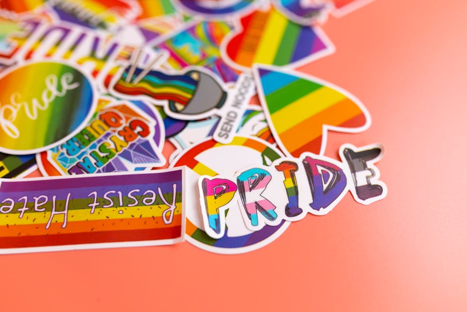 Colorful pride-themed stickers with uplifting slogans on a pink backdrop.
