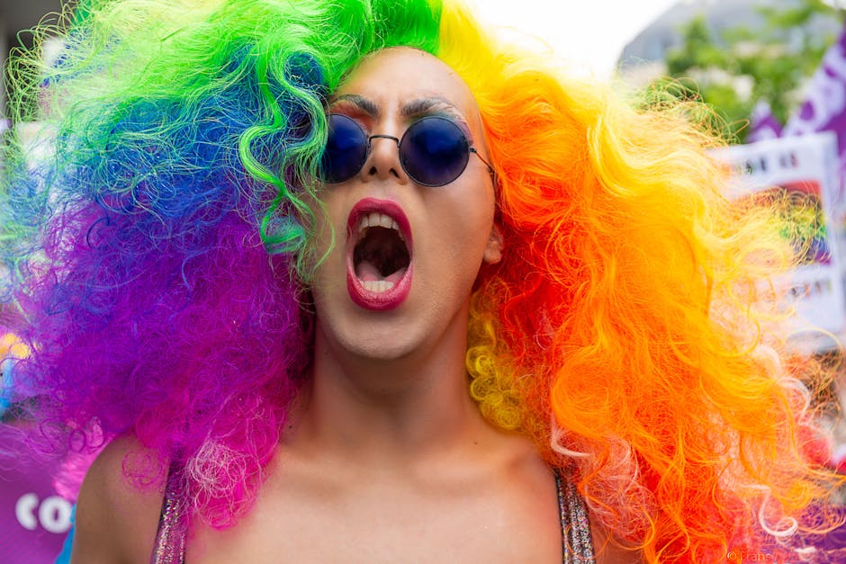 Colorful participant with rainbow wig and sunglasses at Brussels Pride Parade.